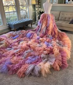 a dress made out of multicolored tulle on the floor in front of a window