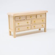 a small wooden dresser sitting on top of a white floor