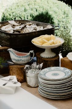 plates, forks and utensils are sitting on a table with an old iron skillet in the background