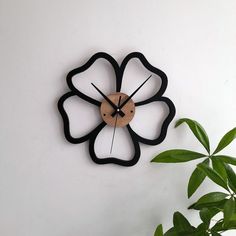 a clock that is on the wall next to a plant