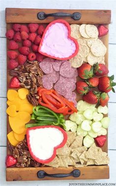 a wooden tray filled with fruit and veggies