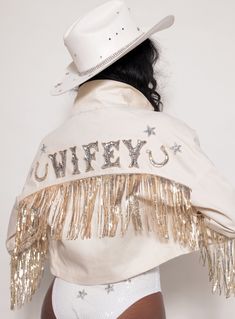 a woman wearing a white cowboy hat and jacket with gold sequins on it