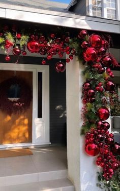 a house decorated for christmas with red balls and greenery