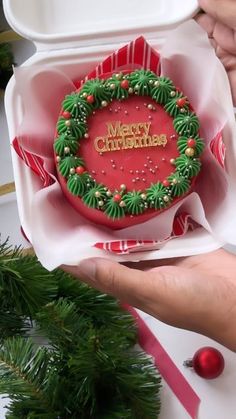 someone is holding a christmas cookie in a box