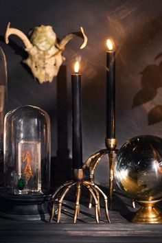 an assortment of candles and other items on a table in front of a mirror ball