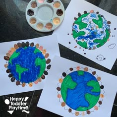 three children's earth crafts are shown on the table with paint and crayons