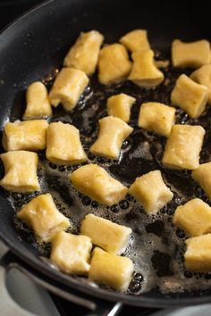 cubed food cooking in a frying pan on the stove