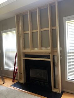 a fireplace being built in the corner of a living room with no one around it