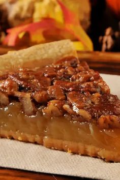 a piece of pecan pie sitting on top of a white napkin