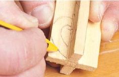 a person is working on some wood with a yellow pen and pencil in their hand