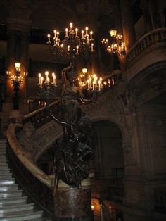 an ornate staircase with chandelier and statue