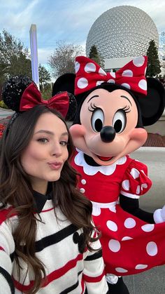 a woman standing next to a minnie mouse