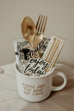 there is a cup with gold spoons and forks in it that says today today