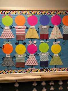 a bulletin board with paper cut out of children's clothes