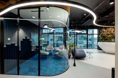 an office with circular glass walls and blue flooring