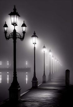 a foggy night with street lights on the pier