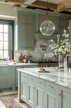 a kitchen with green cabinets and marble counter tops