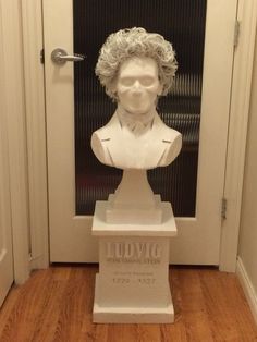 a bust of a man with curly hair in front of a door