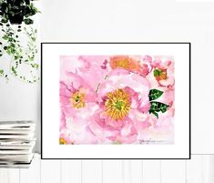 a pink flower with green leaves on the wall next to a potted plant and books