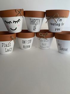 six plant pots with sayings on them