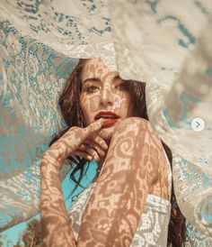 a woman laying on top of a blue and white blanket