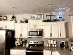 a kitchen with white cabinets and silver appliances