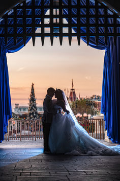 a bride and groom kissing under an archway