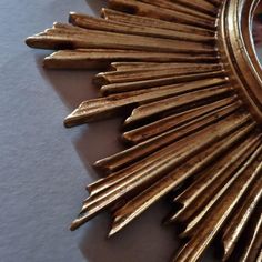 a gold sunburst shaped mirror sitting on top of a table