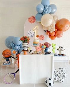 a table topped with lots of balloons and sports items