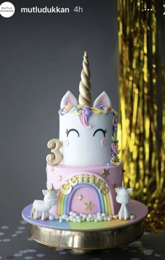 a birthday cake decorated with an unicorn and rainbow