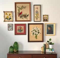 there are many framed pictures on the wall with flowers and birds in them as well