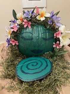 a green pumpkin decorated with flowers and grass