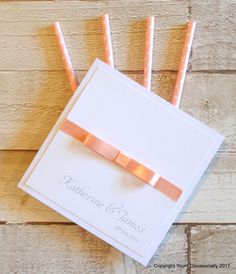 the wedding stationery is set up with pink and orange straws in it's box