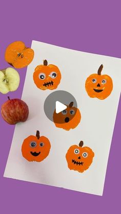 an apple and some oranges with faces drawn on them in the shape of pumpkins