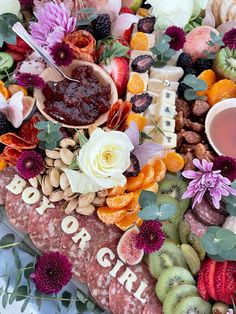 an assortment of fruits and flowers on a platter