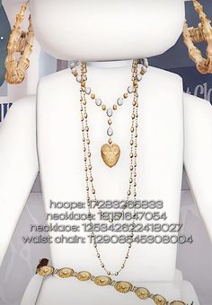 a white mannequin with gold jewelry on it's chest and hands holding onto the neck