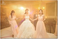 three women in dresses are dancing on the dance floor