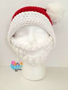 a crocheted santa hat with red and white pom - poms