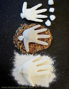 two white gloves and some food on a black table with one glove next to it