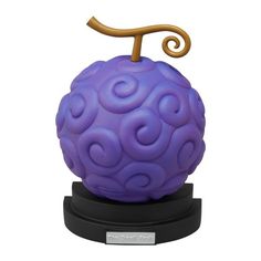 a purple ball with a golden t on it's top sitting on a black stand