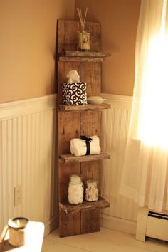 a wooden shelf with towels on top of it next to a window in a room