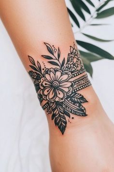 a woman's arm with a flower tattoo on the wrist and an arrow in the middle