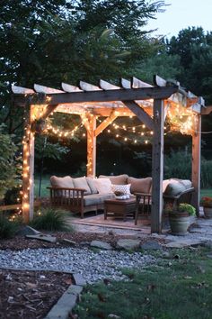 an outdoor living area with patio furniture and string lights on the pergolated roof