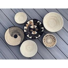 several woven baskets sitting on top of a wooden floor next to each other with different shapes and sizes