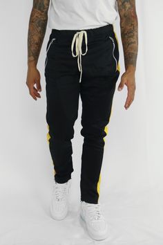 Color: Black - Yellow Fit: Skinny Product Details:• Full Yellow Side Stripe Design.• Zip Pockets To Hold Phone. 📱• Hidden Ankle Zips.• Slim Fit Stretch Material.• 100% Polyester. ☁️*This Item May Come With An Off-White Or Solid White String.* (ZCM4418Z) Dope Fits, Yellow Fits, Pant Trends, Red Fits, Black Bottoms, Black 7, Side Stripe, Pants Black, Trending Now