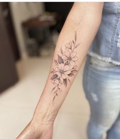 a woman's arm with a flower tattoo on the left side of her wrist