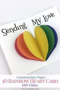 the construction paper 3d rainbow heart card is on top of a white piece of paper