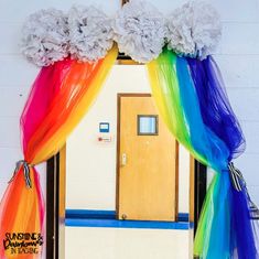 the door is decorated with rainbow colored tulle curtains and flowers on it's side