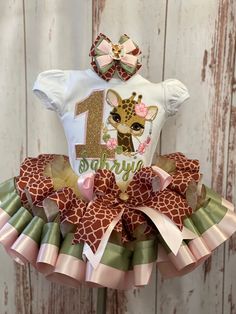 a baby girl giraffe birthday outfit with pink and green ruffles on the bottom