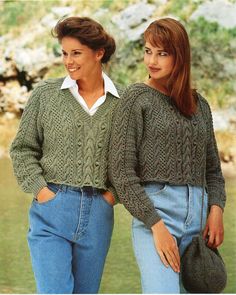 two women standing next to each other wearing sweaters and jeans with their hands in their pockets